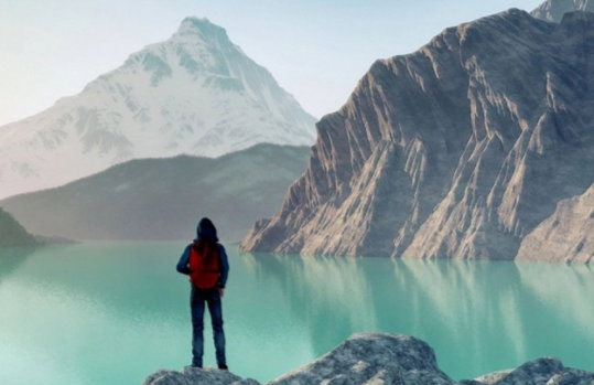 Eine Person steht vor einem türkisgrünen Gebirgssee.