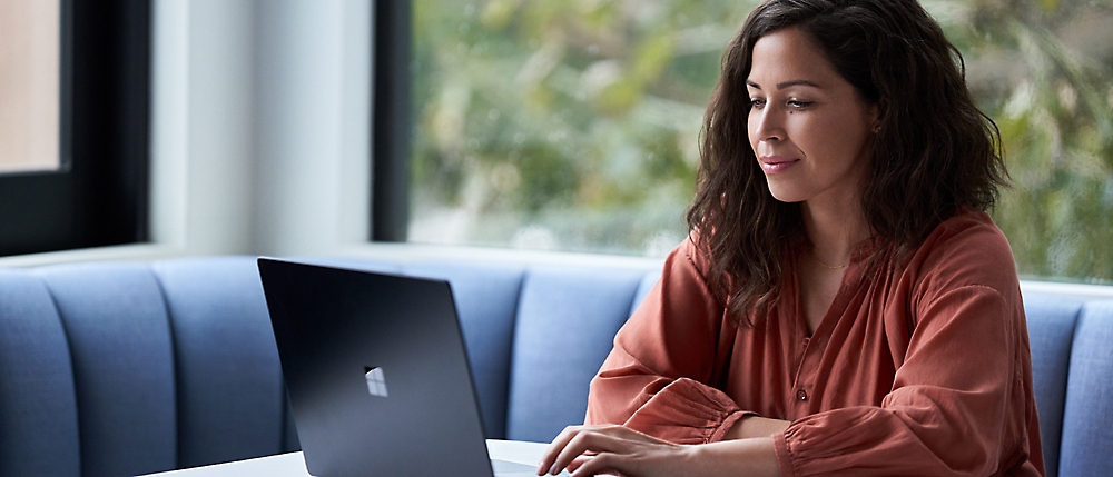 A person sitting on a couch using a computer