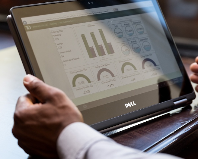 A person holding tablet in his hand and looking dashboard screen