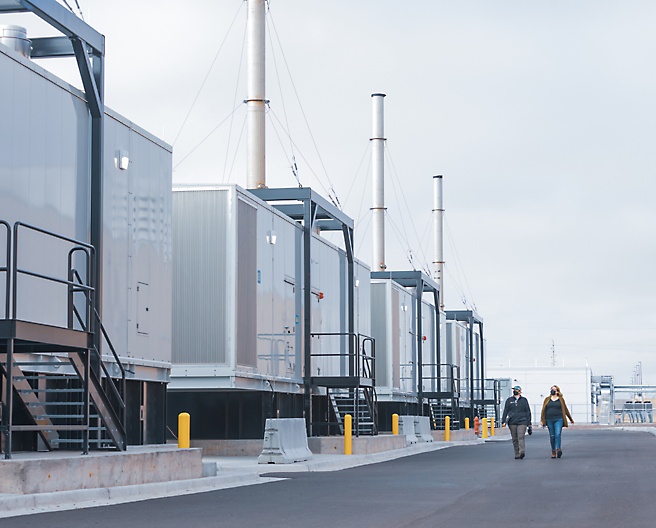 Two people walking in a manufacturing unit on the road.