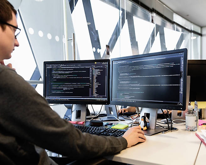 A person working with multiple desktop screen