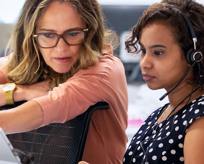 Two women are sitting and looking at the laptop