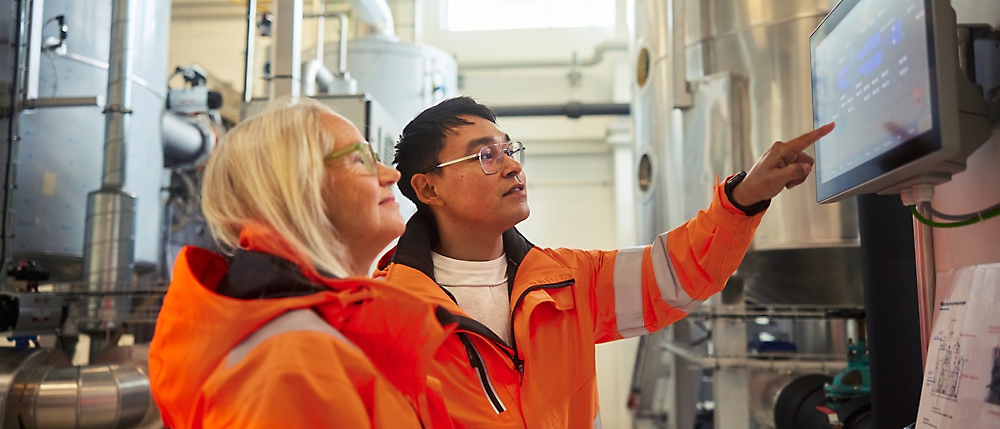 A person and another person in orange jackets