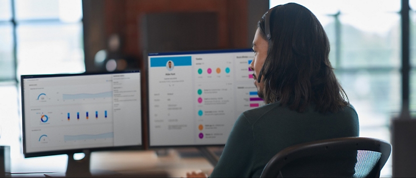 A person wearing headphones looking at a computer screen