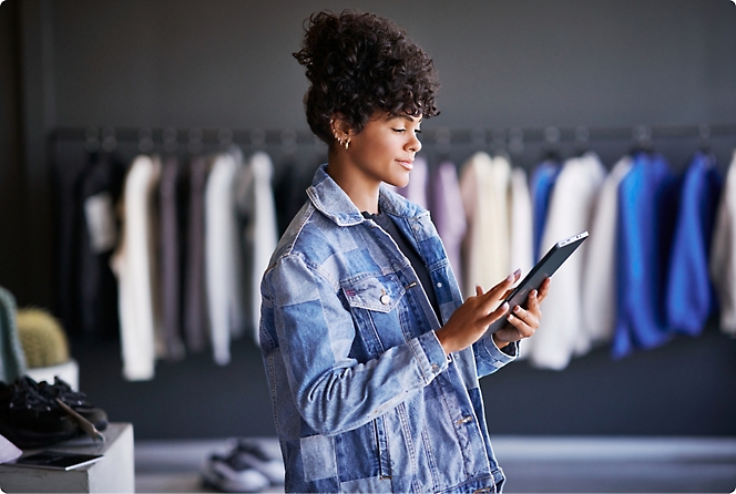 A woman in an apparel store checking her tablet