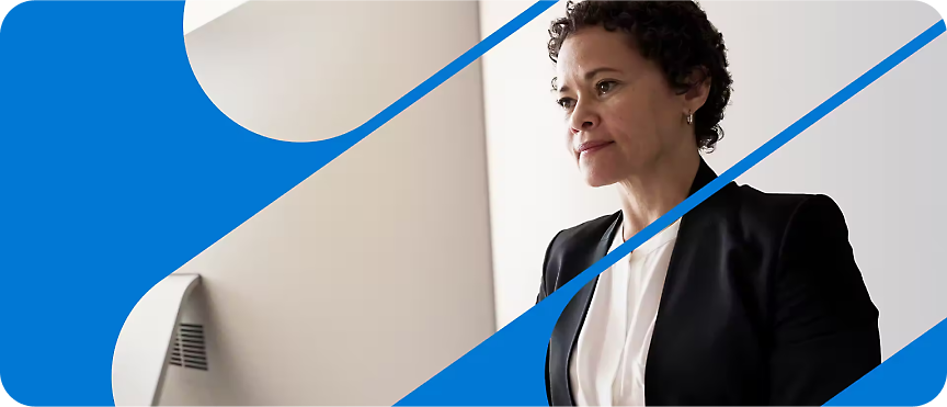 A women in a suit standing in front of computer