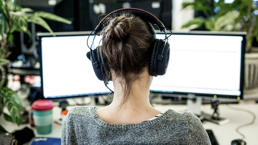 Una persona con auriculares trabaja en su escritorio.