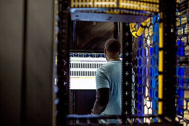 A person looking in the monitor in server room