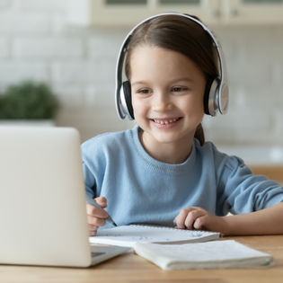 A child wears headphones while using a computer. 