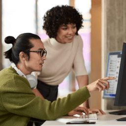 A man and woman building an app together on a computer.