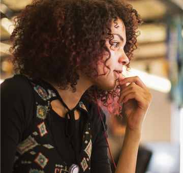 A pro dev woman looking at a monitor creating a Power Platform low-code solution