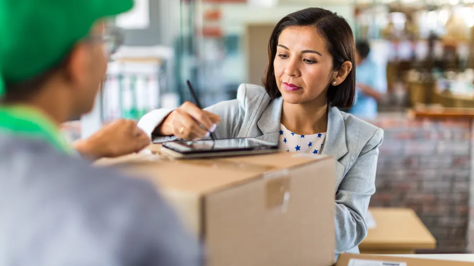 a woman signing for a delivery package