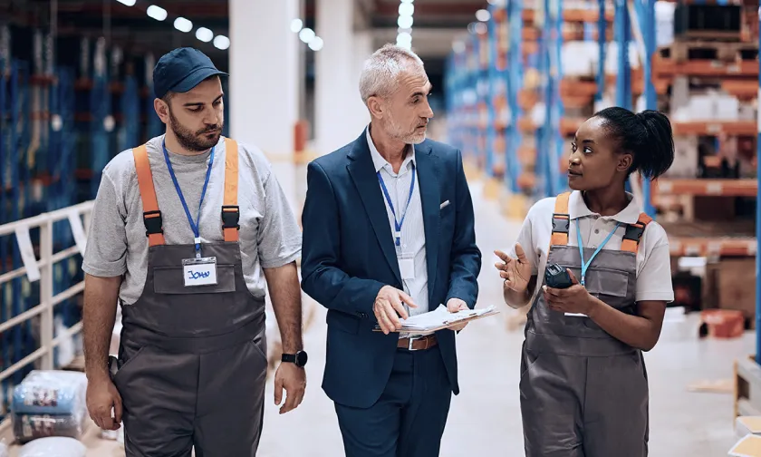 3 workers talking in a construction warehouse