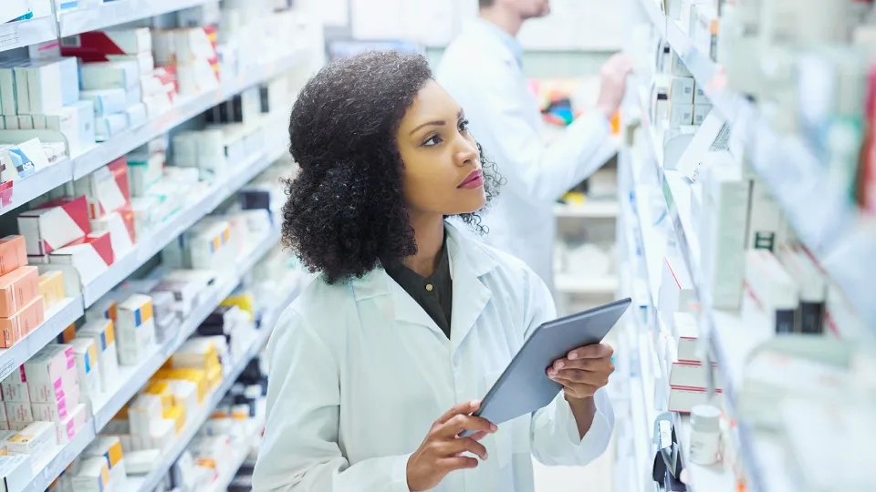 a person looking at different meds on a pharmaceutical rack