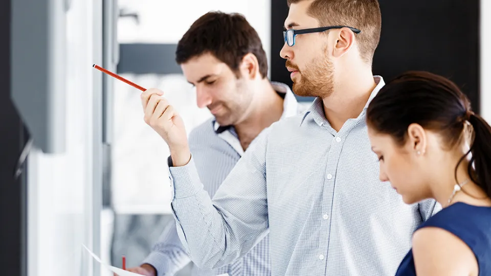 A group of people looking at a screen and discussing