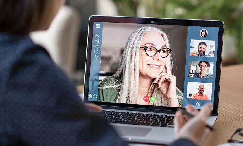 Close up of a woman speaking on a remote call as seen on a laptop screen