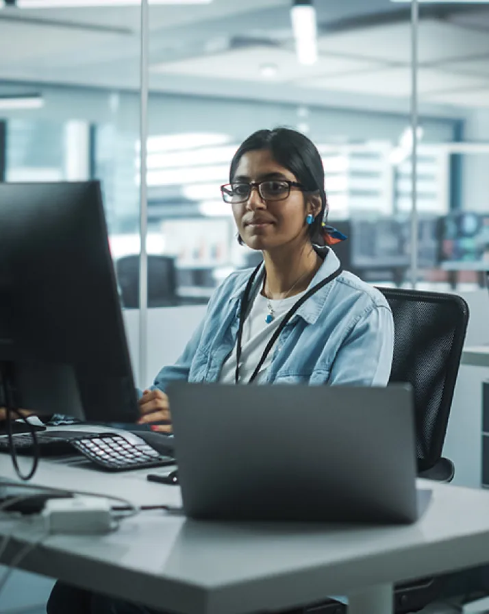 A woman working at a desk with a laptop