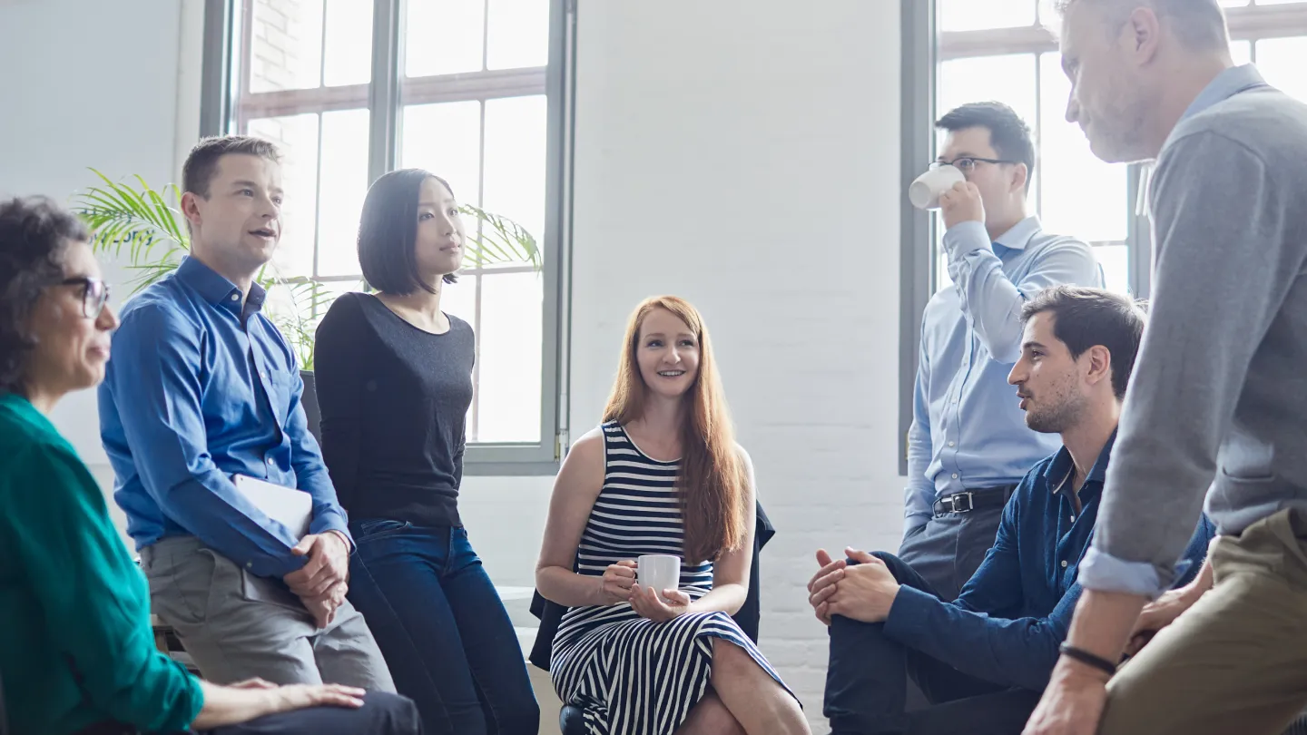 a group of people having a discussion in an office