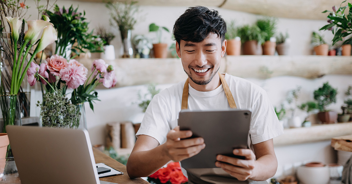 Man in his business space looking down at a tablet.