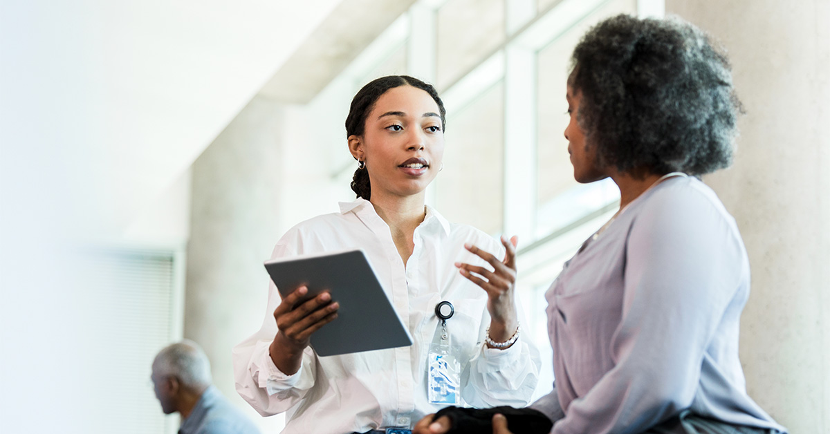 Two woman talking in an office entryway.