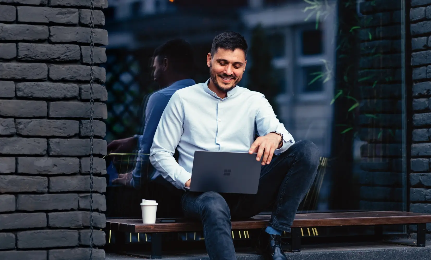 Person looking at laptop sitting outside