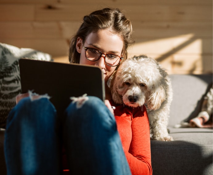 Femme à la maison en compagnie d'un chien.