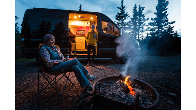 Two travelers park their campervan near a fire pit, Teklanika campground.