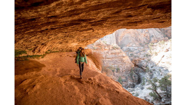 A mother and her son hiking a scenic trail through a cave.