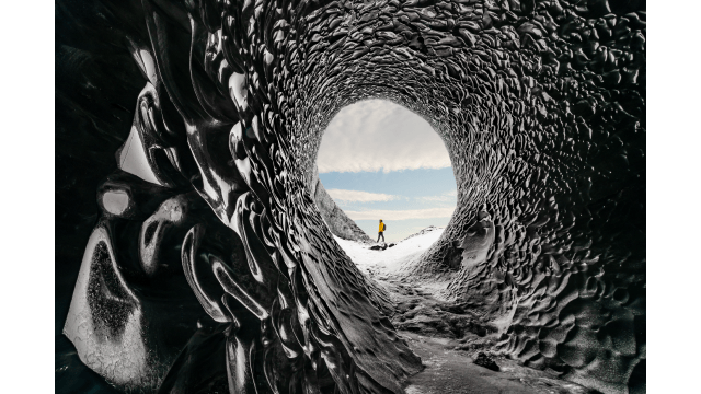 Man exploring an amazing glacial cave in Iceland.