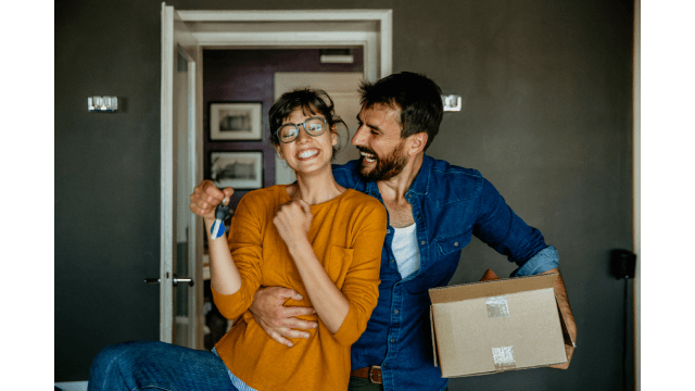 Portrait of a happy woman and man, holding keys for their new first home.