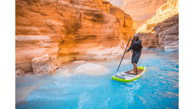 Man paddleboards up Havasu Creek near the Colorado River in Arizona.