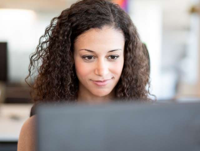 Woman smiling looking at laptop