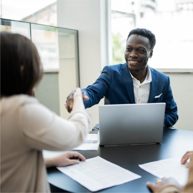 Coworkers shaking hands in office