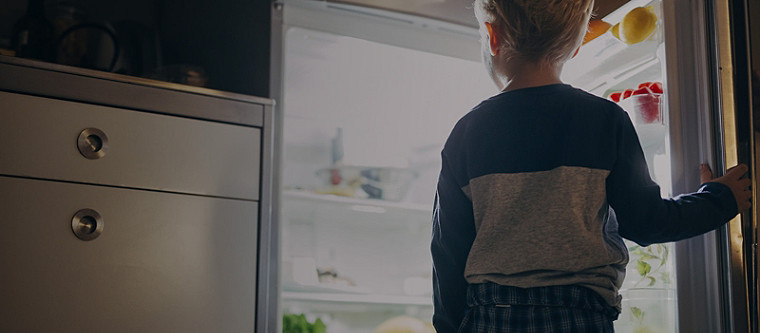 garçon regardant dans un réfrigérateur