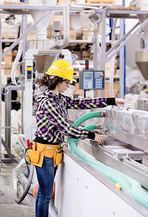 Mujer comprobando la máquina de fabricación