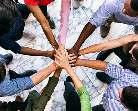 A group of people holding their hands together