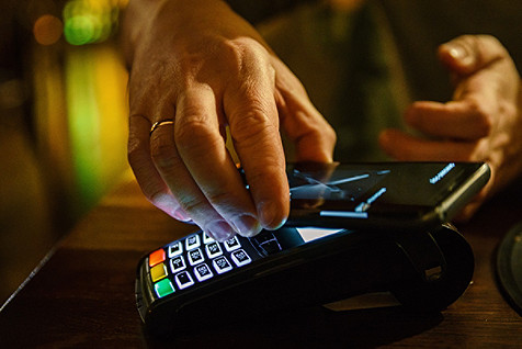 person tapping phone on a card machine