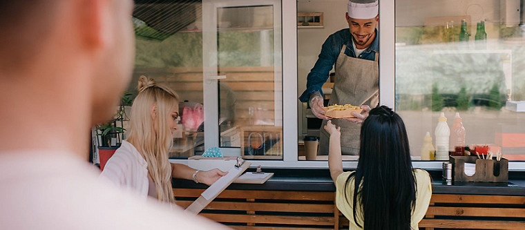 chef servant une assiette de nourriture à une femme