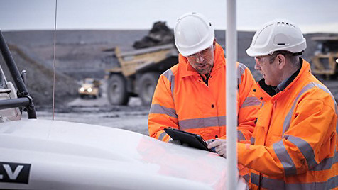 two factory workers looking at computer screen