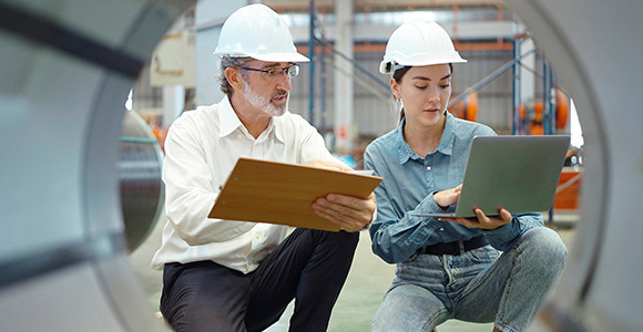 Executives on the floor of some type of manufacturing facility