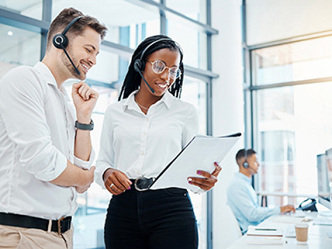 two employees with headphones in conversation 