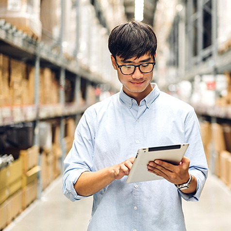 man in warehouse working on tablet