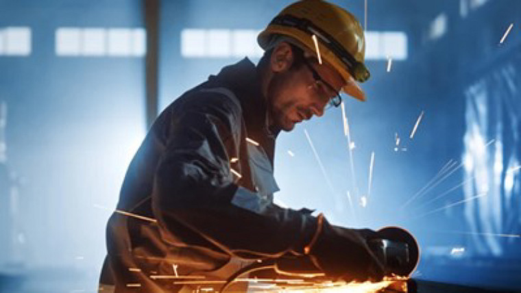 Person operating a grinding tool on steel