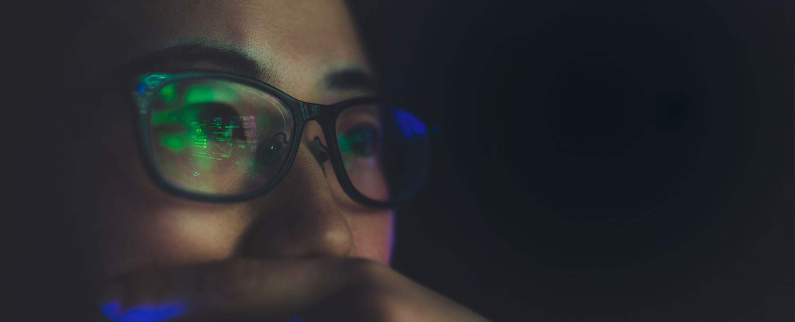 Close-up of the reflection of a screen in a woman's glasses