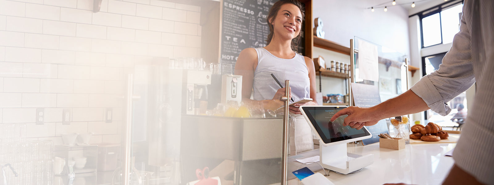 A woman taking order from a customer at a coffee shop