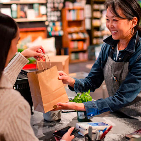 woman handing a bag to another woman