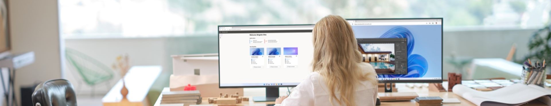 Woman working on computer with two monitors