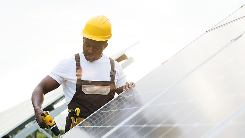 person working on solar panel