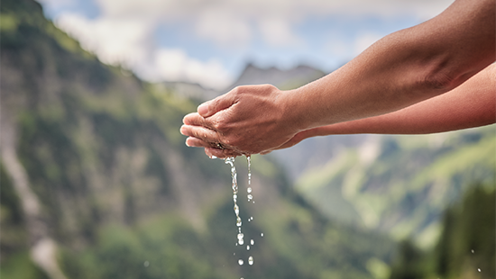 Hands catching running water