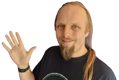 Photograph of Dan, his ponytail hanging over the shoulder of his black t-shirt, smiling from behind his beard and waving to the camera.